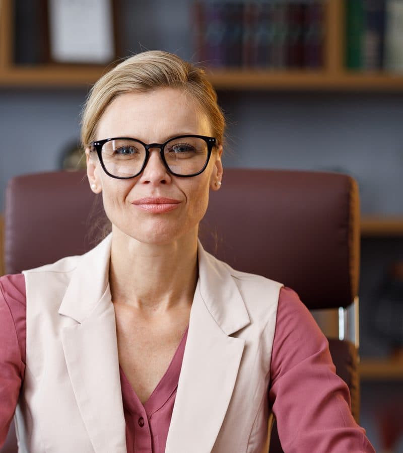 Žena v okuliaroch pri pracovnom stole v kancelárii